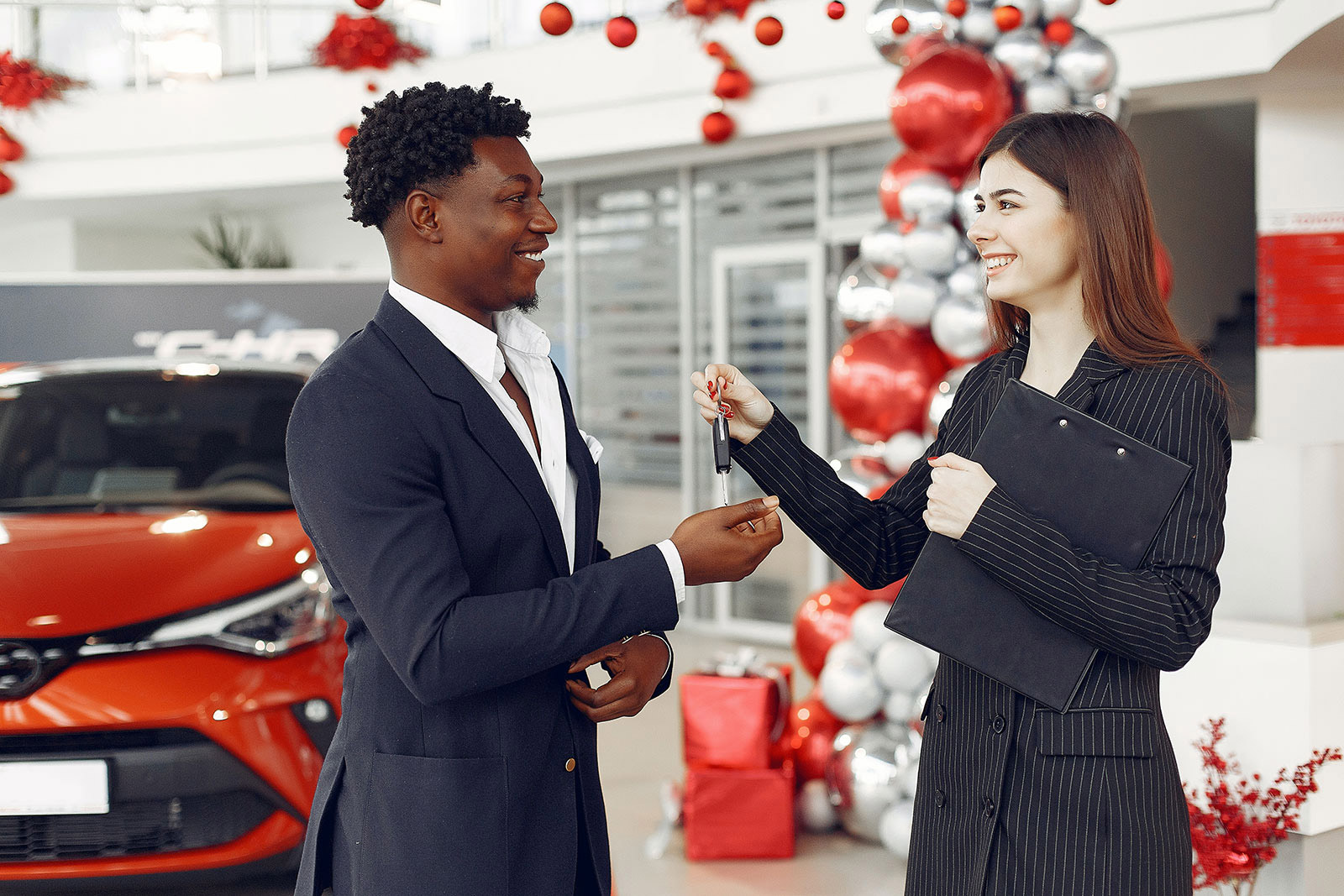 Car saleswoman handing consumer car keys