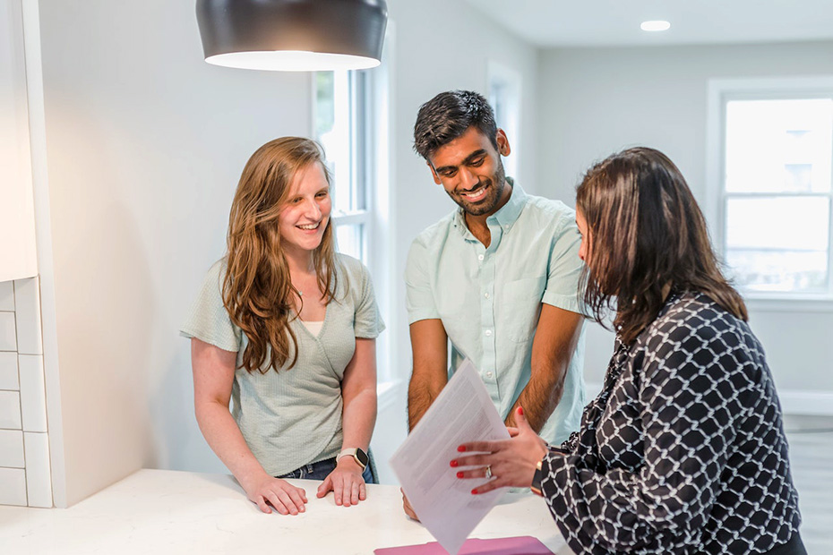 Couple happily signing mortgage papers for a house