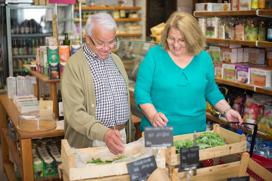 elderly couple happily buying groceries
