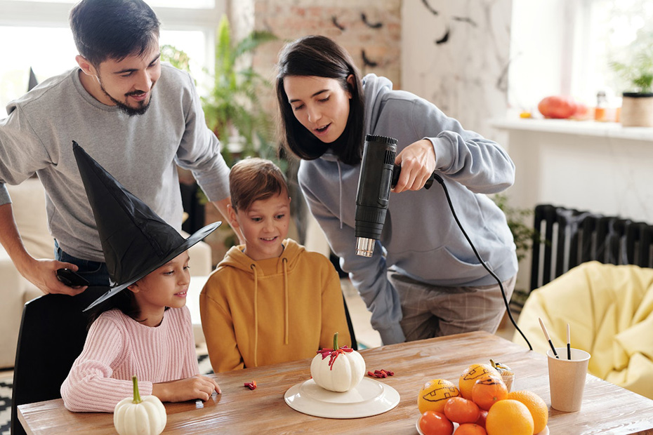 Family having fun making fall decorations at a kitchen table