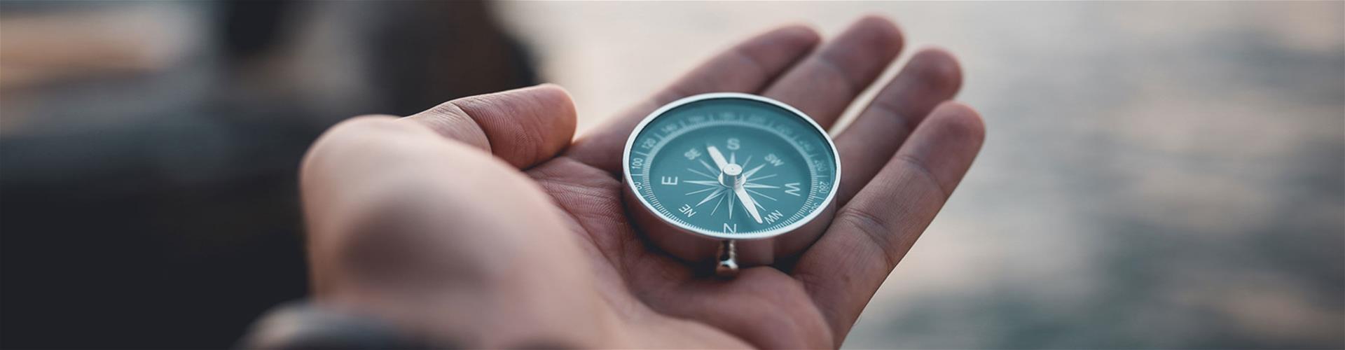 Person holding a compass at dusk