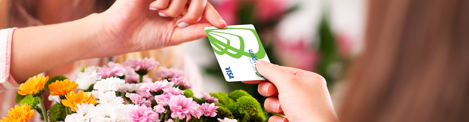 Happy female paying for flowers with Wildfire Visa Credit Card