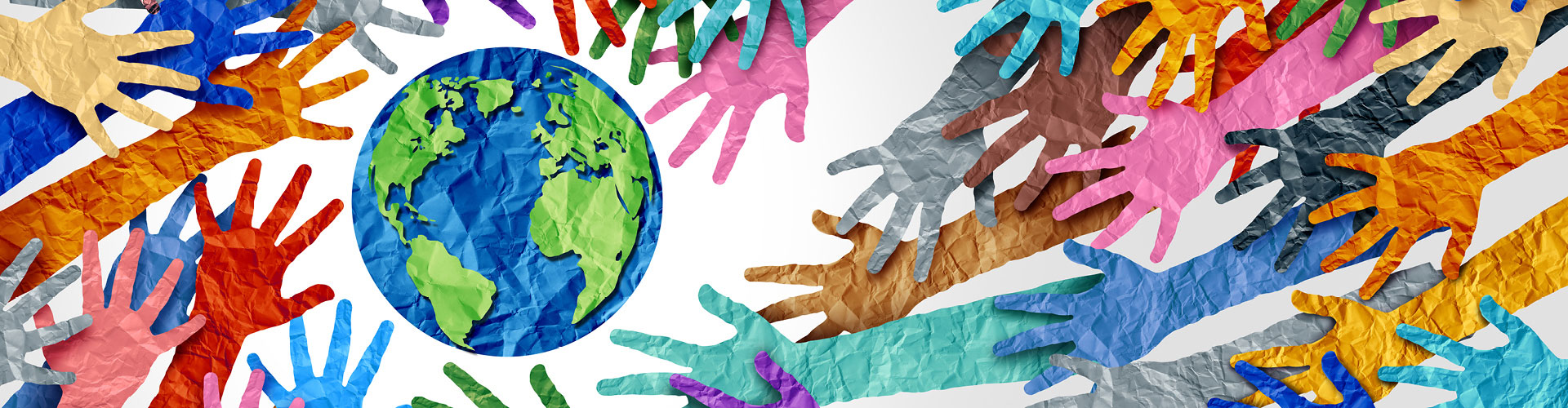 Multiple paper hands of different colors surrounding a paper Earth