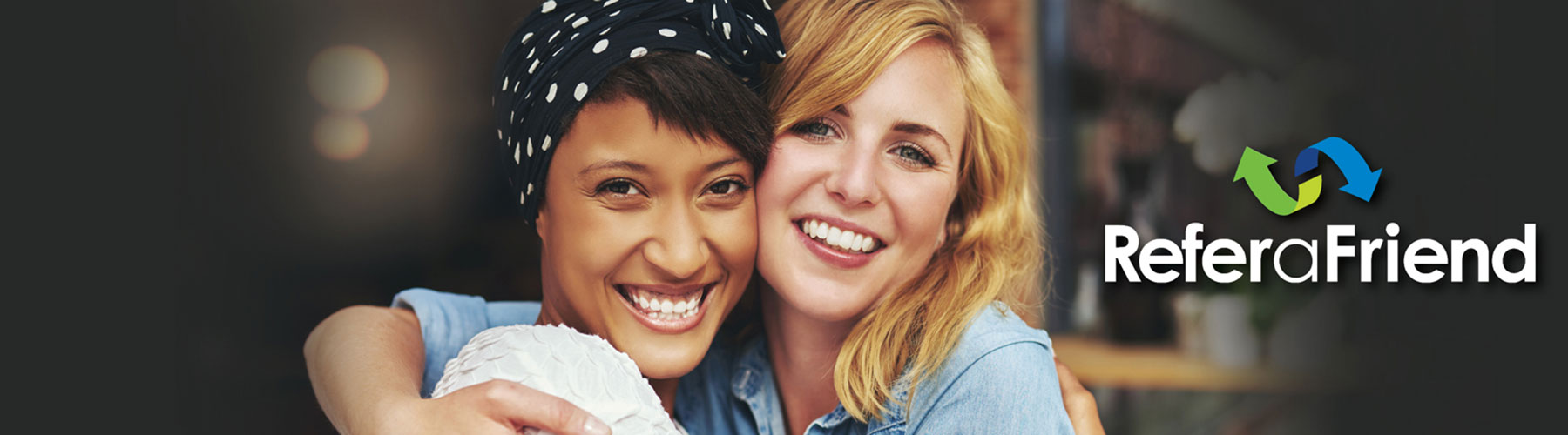 Two female friends smiling and hugging each other