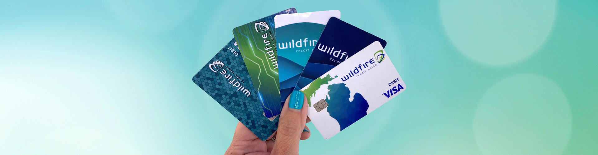 A person holding Wildfire Visa credit cards