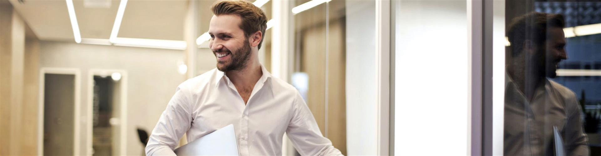 Smiling business man walking down hallway