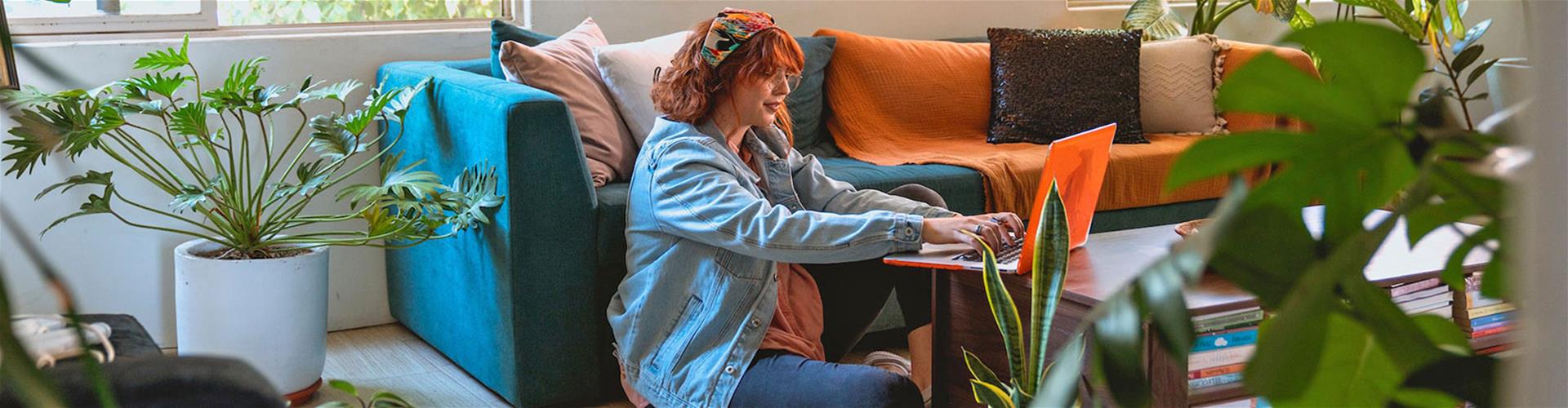 Woman happily using her laptop in living room