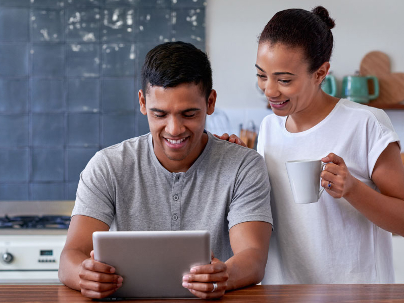 Couple looking at their mobile device to see how they can use Work Place Perks