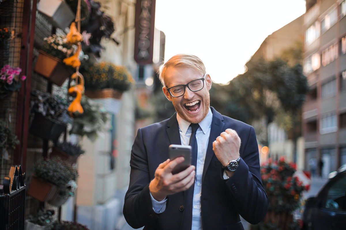 Excited Business man on his phone in the city