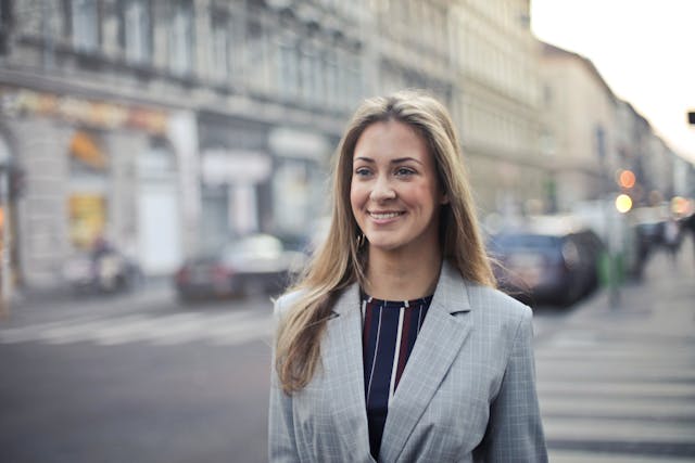 Smiling business woman wearing business casual clothes confidently walking through town