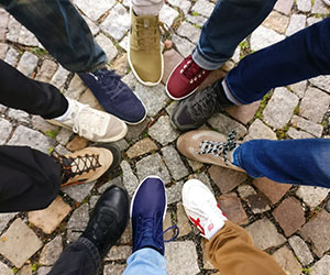 People standing in circle with their feet in the middle