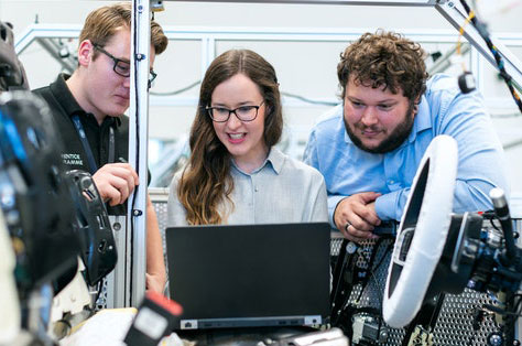 Engineering team happily working on computer