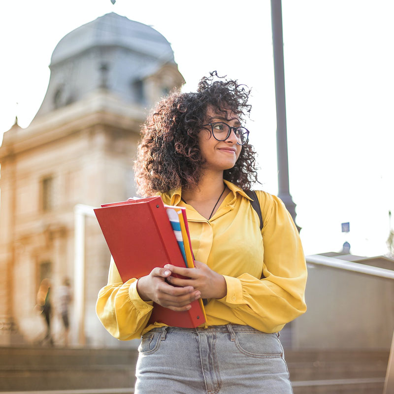 Female Student In Yellow Jacket Holding Books Female Student In Yellow Jacket Holding Books