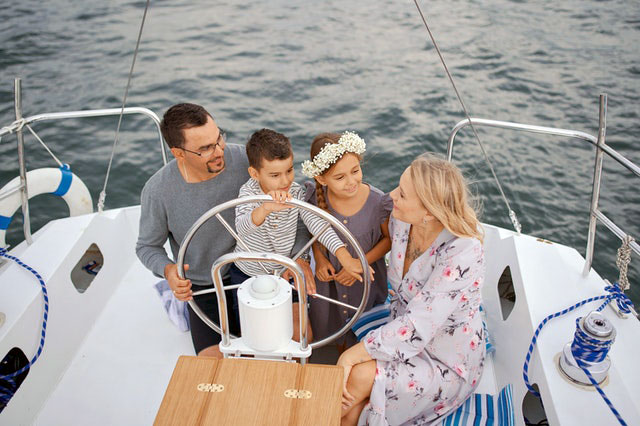 Happy family on yacht sailing on sea during trip
