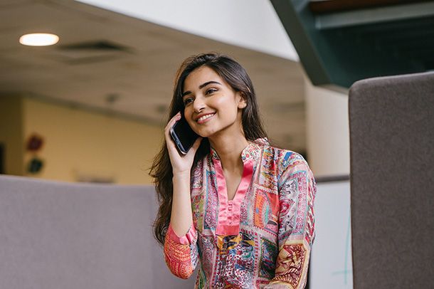 Smiling Woman in Floral Salwar Kameez Talking on Phone