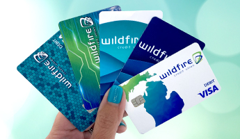 Person holding Wildfire credit and debit cards