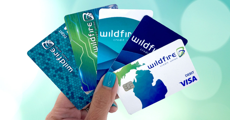 Person holding Wildfire credit and debit cards