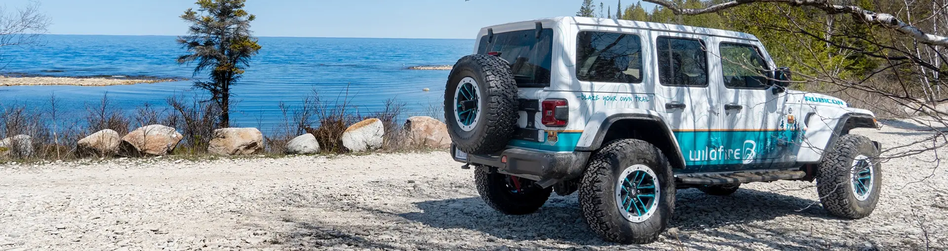 Wildfire Jeep Wrangler in northern Michigan on a gravel road by the lake.