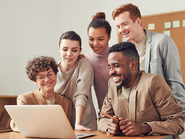 Happy Business owner and employees working on laptop