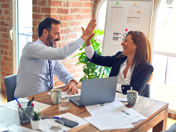 Two middle age business workers Working together with smile hand giving high five Two middle age business workers Working together with smile hand giving high five