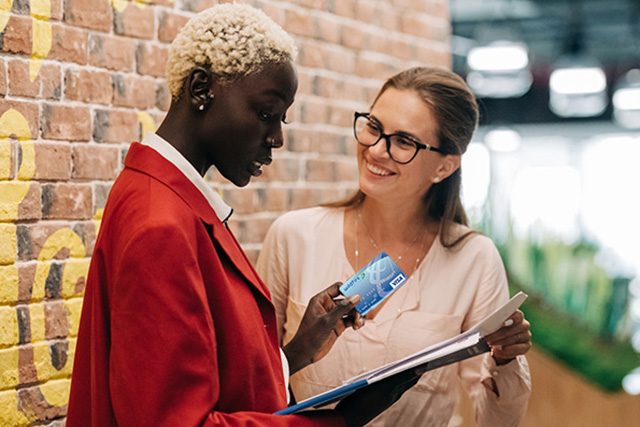 Businesswomen with Wildfire Visa Credit Card discussing credit card payment Businesswomen with Wildfire Visa Credit Card discussing credit card payment