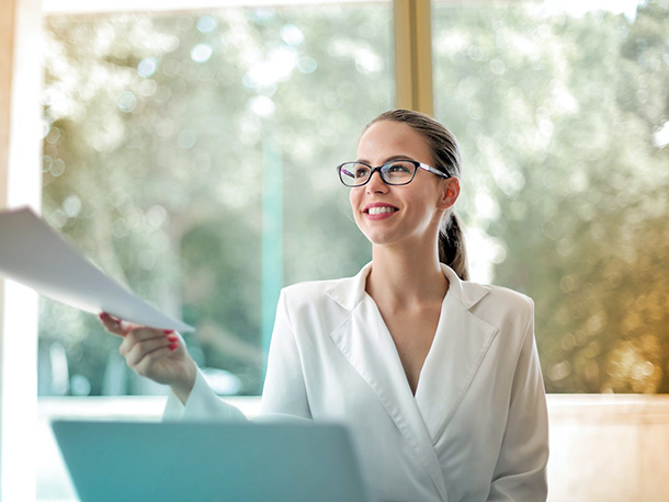 Positive business woman handing off paperwork Positive business woman handing off paperwork