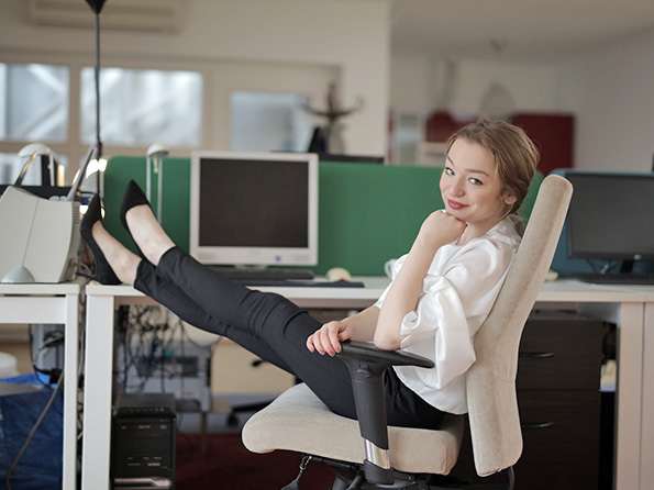 Smiling employee with feet on desk Smiling employee with feet on desk