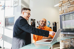 Two co-workers happily working on computer