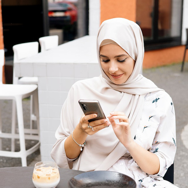 woman wearing hijab using a smartphone