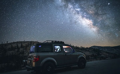 Car driving at night under the stars