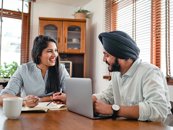 cheerful couple discussing finances at home cheerful couple discussing finances at home
