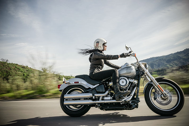 Female on motorcycle speeding down open highway on partly cloudy day