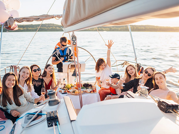 Group of people having a party riding a boat at sunset