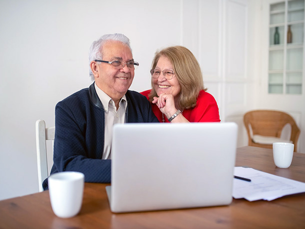 Happy elderly computer working on computer