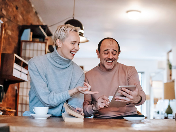 Joyful multiracial middle aged couple using a tablet