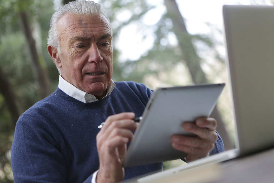 Senior male outside working on a tablet