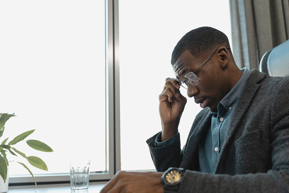 Slightly stressed young adult male sitting at a desk