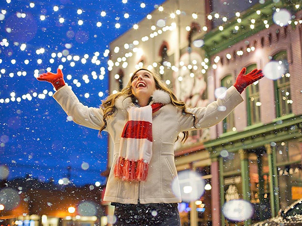 Female joyfully celebrating in downtown Bay City street at night during winter