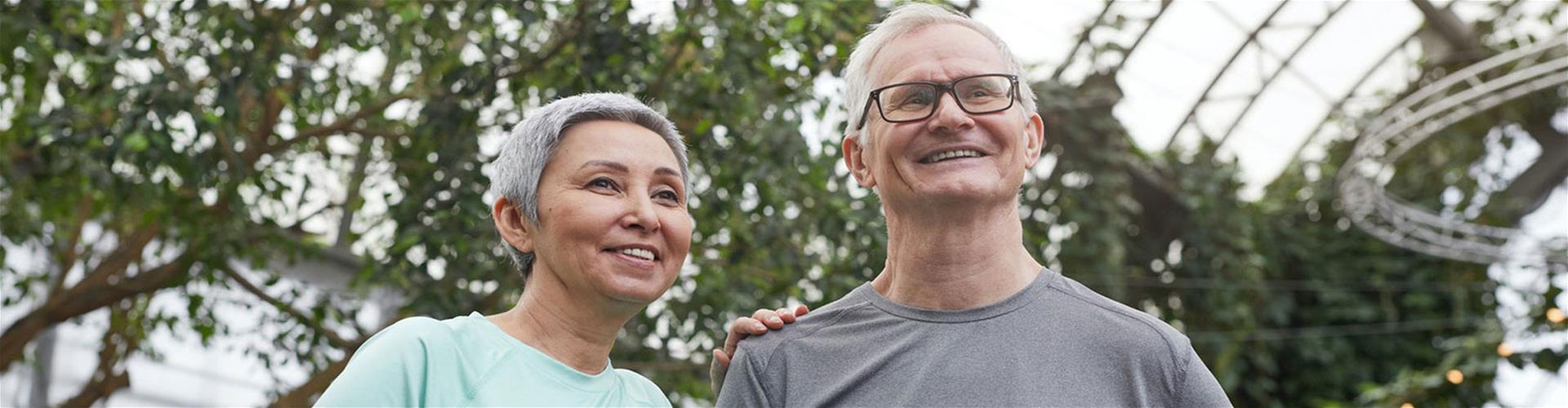 Happy Optimistic Elderly couple exploring a garden