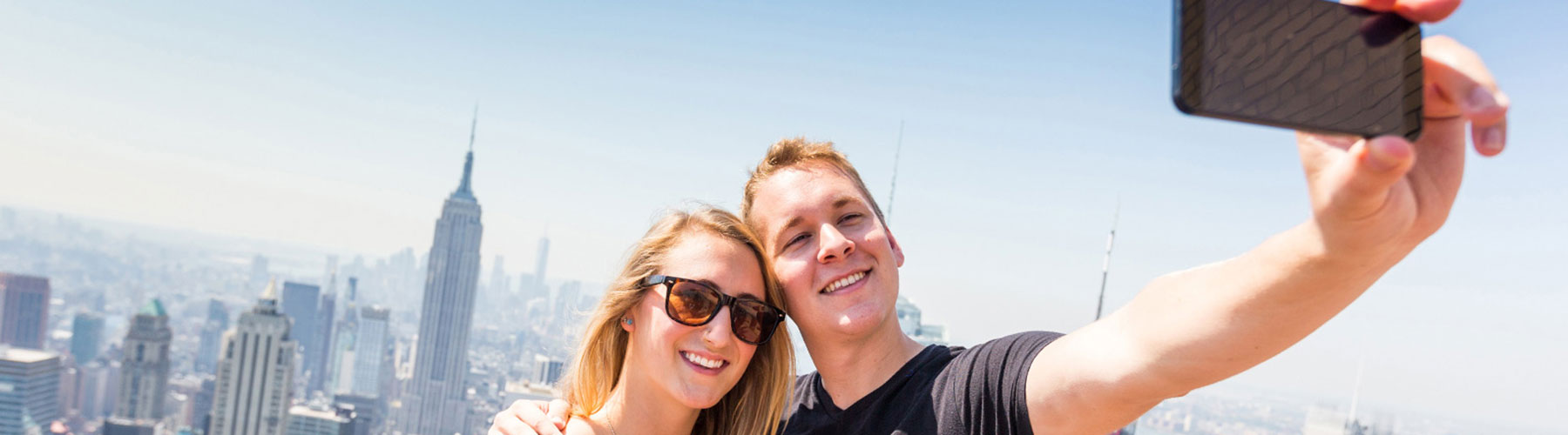 Couple taking selfie with skyline in background