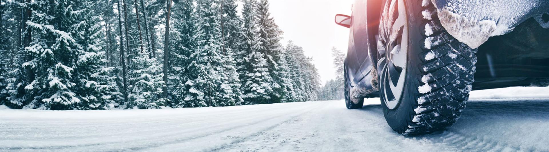 Car driving down snowy road