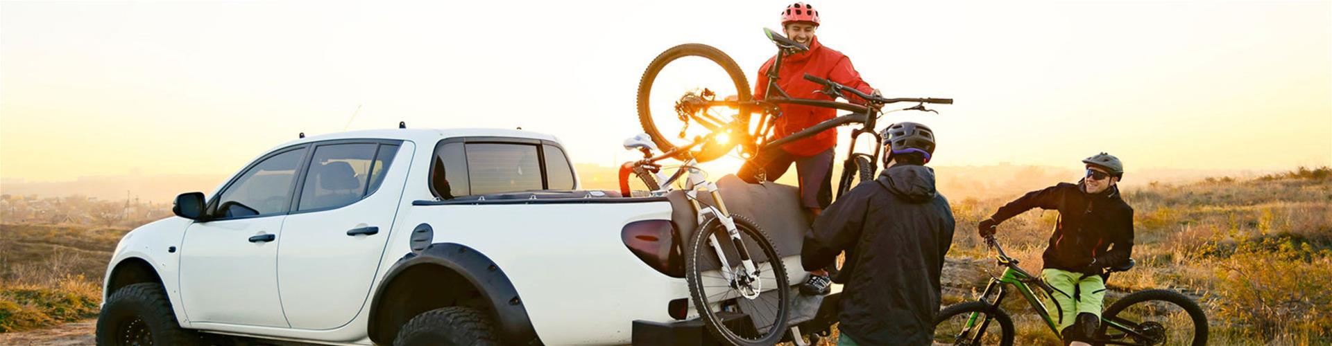 Group of friends unloading mountain bikes from a pick up truck