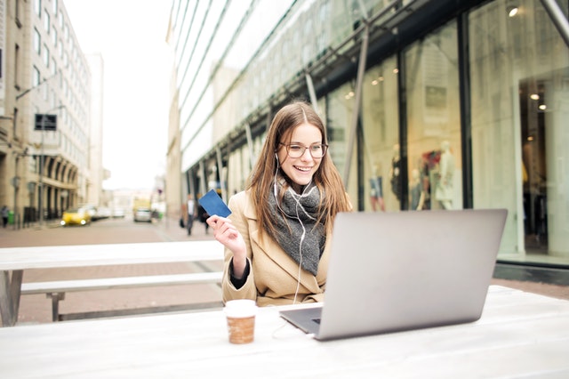 Happy woman in brown coat online shopping