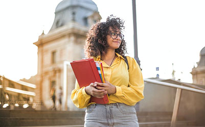 Female Student in Yellow Jacket Holding Red Book