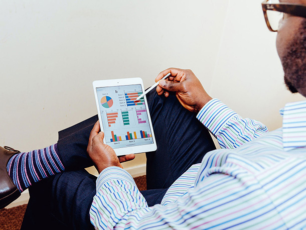 Man in business casual clothing Analyzing his investments on a tablet