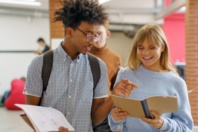 young man and woman having a happy conversation at school