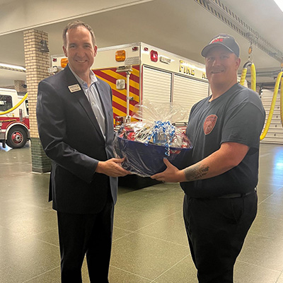 Ben Denay delivering basket of goods to local Fire Department for CU Kind Day 2024