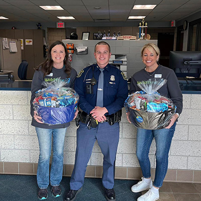 Tricia Schabel and Katie Jankens deliver basket of goods to local police department for CU Kind Day 2024