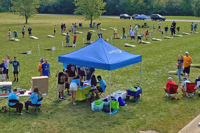 People out playing cornhole at a Wildfire cornhole tournament