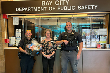 Wildfire Employee giving gift basket to police officers